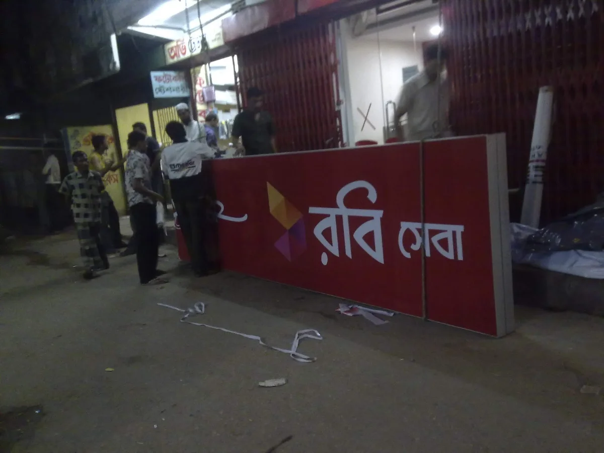 Robi service signage being installed at night in Jigatola